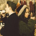 Woman in black coat and black and white hat