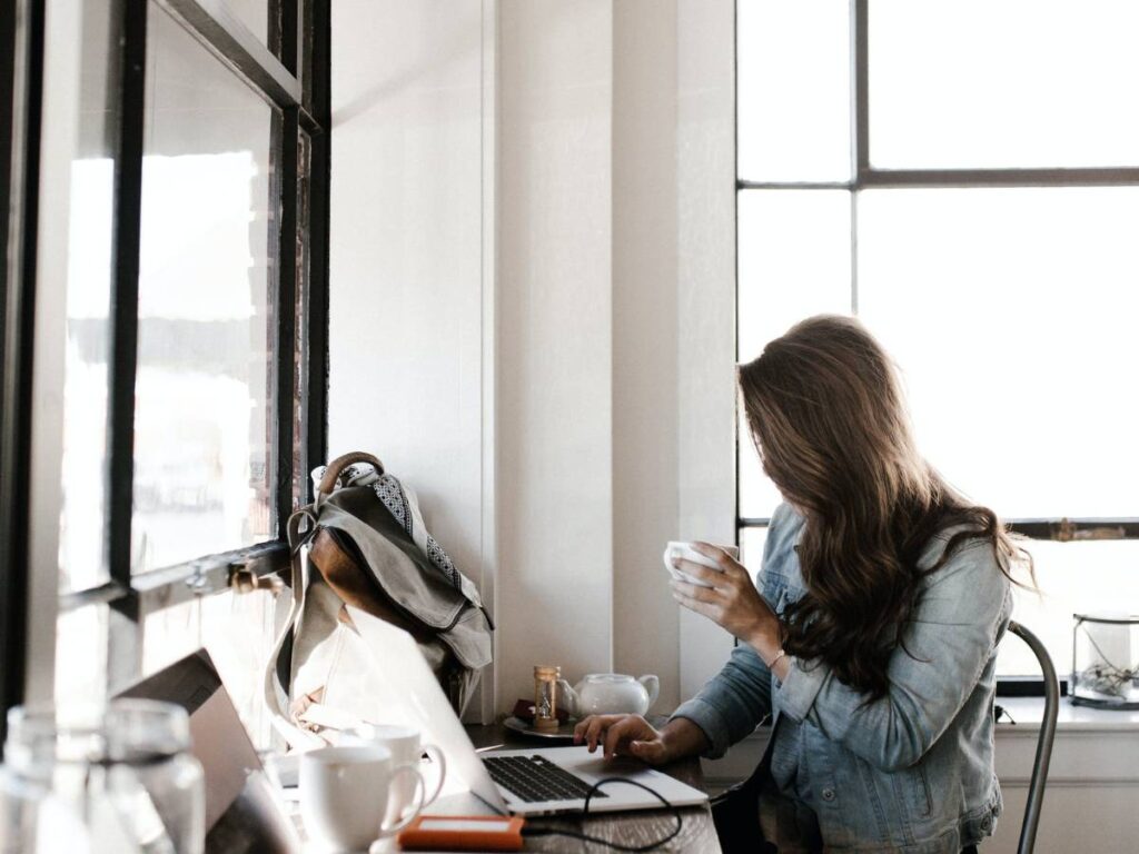 Woman in Gray Jacket Sitting Beside Desk