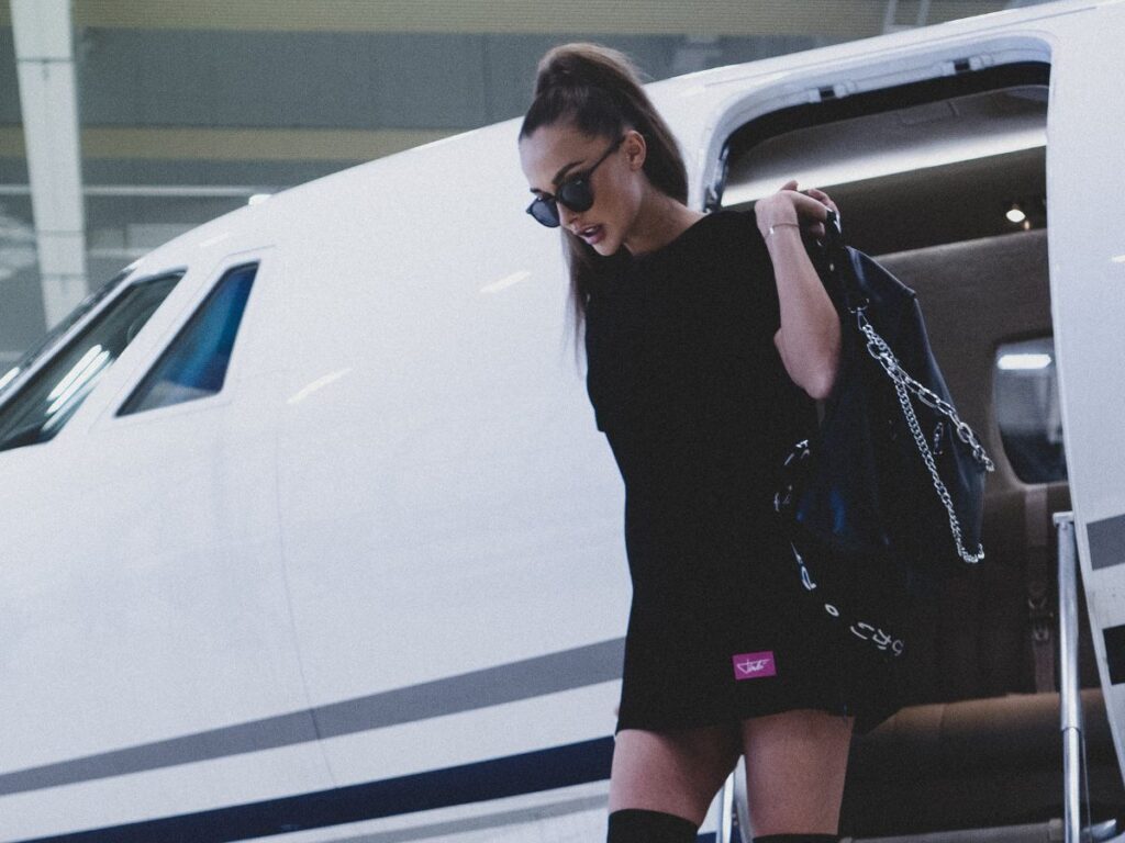 Unknown celebrity wearing black dress carrying black leather bag
