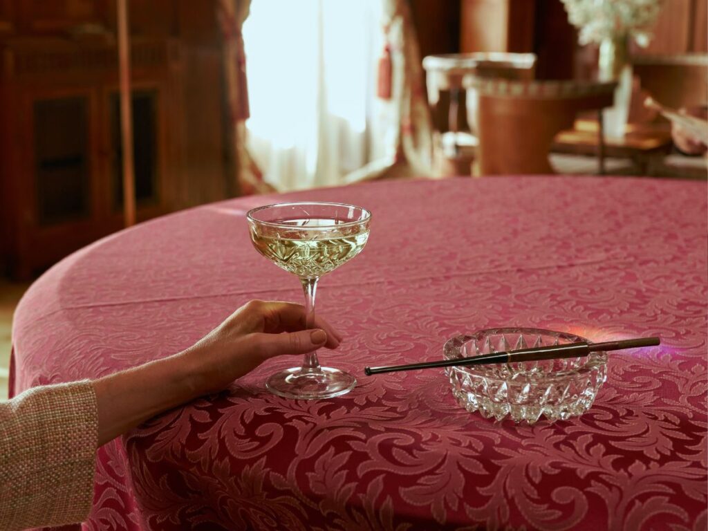 Female hand holding-glass of wine in a luxury interior