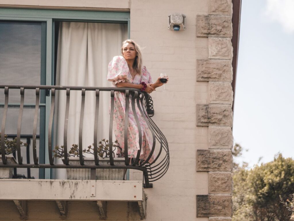 Woman standing on balcony with wineglass