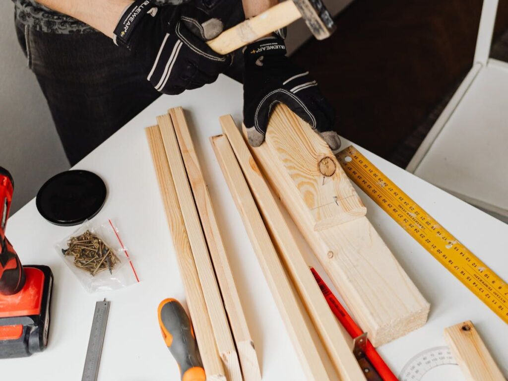 Person hammering a nail into the wood