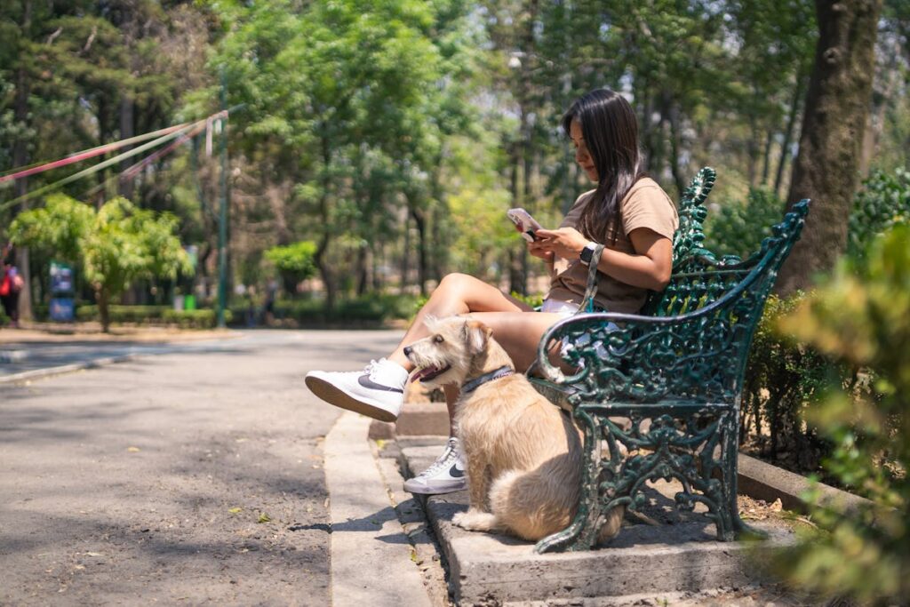 A Woman Sitting on a Bench with a Dog