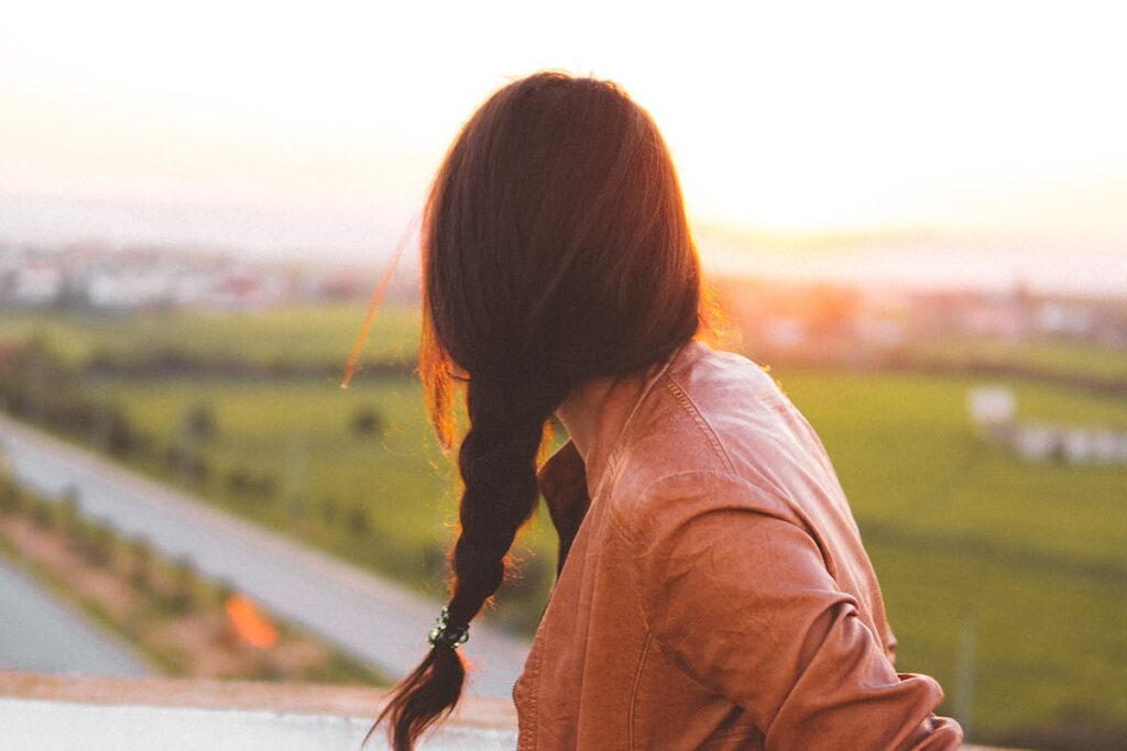Woman Wearing Brown Leather Jacket Standing and Looking on Grass Field View at Day Time