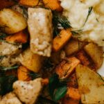 Delicious fried potatoes and chicken dish with carrots and herbs